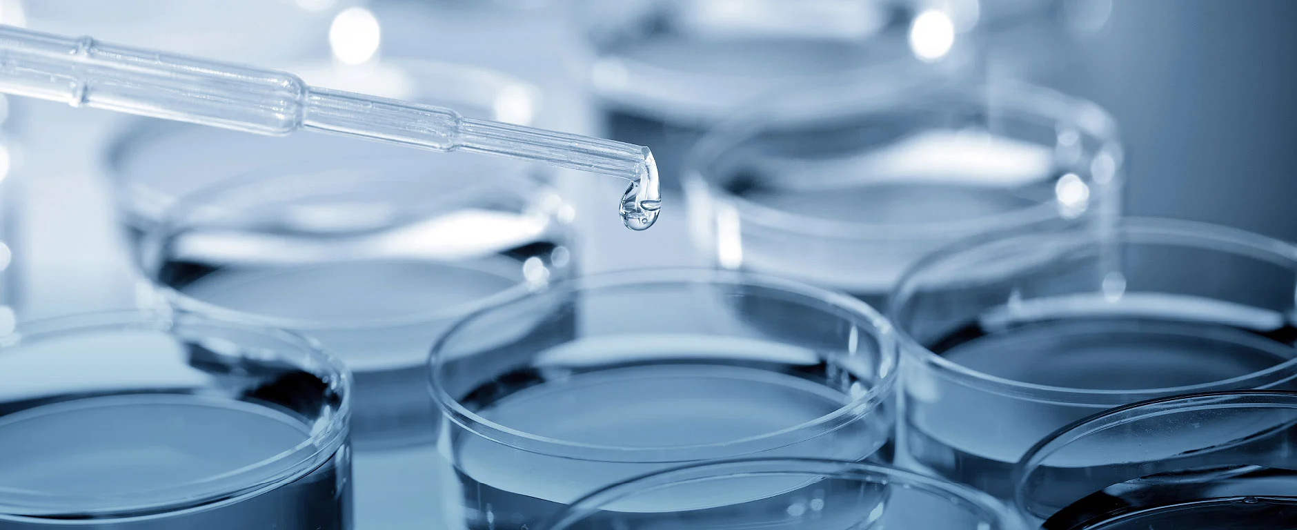 Wassertropfen in Laborumgebung als Symbol für Biozide gegen Mikroorganismen.