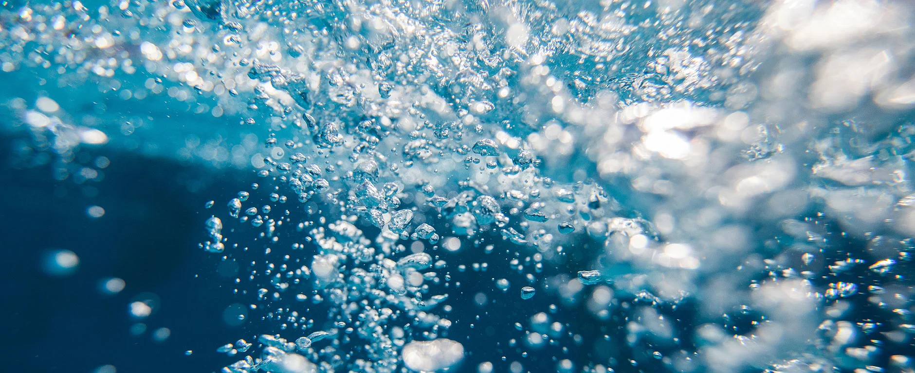 Luftblasen in klarem Wasser als Symbol für Qualität in der Wasserbehandlung.